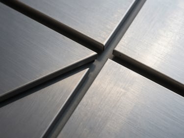 Extreme close-up of brushed titanium panels, sharp geometric lines, cool metropolitan light, architectural detail.