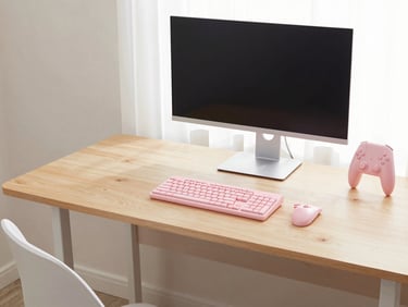 Pastel wood gaming computer desk with a monitor, keyboard, and gaming accessories, soft diffused daylight, clean composition.