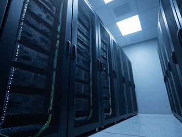 Low-angle wide shot of an empty high-end corporate server room, clean cabling, cool blue dramatic lighting