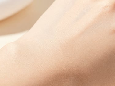 Macro shot of natural skin texture under warm, bright daylight, showcasing health and subtle glow, shallow depth of field.
