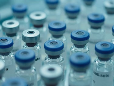 Close-up of lyophilized powder vials in a sterile cleanroom environment, teal and blue cinematic highlights