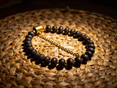 A single Opele Ifá made of dark seeds and brass chains, laid carefully on a rustic woven straw mat, dramatic low-key lighting with deep shadows, warm golden side-light, 35mm