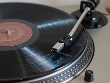 Macro photograph of a vinyl record groove spinning on a turntable, cold-cathode blue light reflection.