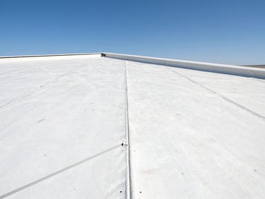 Close-up of a seamless multi-ply flat roof installation, heavy structural seams, bright high-contrast desert sunlight