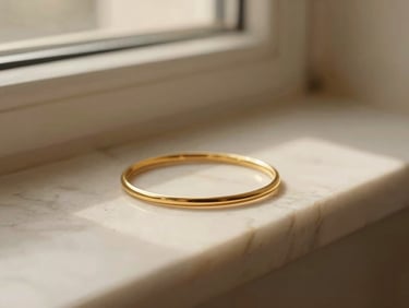 Extreme close-up of delicate gold jewelry resting on warm marble, soft shadows, quiet luxury aesthetic, 35mm