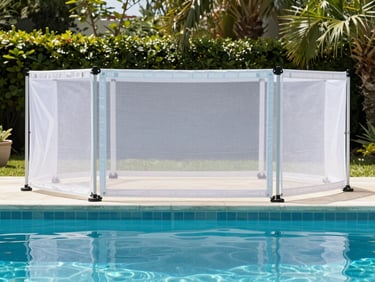 Outdoor residential pool surrounded by a clean white removable safety fence with mesh panels, sunny daytime, lush garden visible in the background