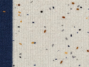 Macro-texture photograph of a mixed textile composite panel showing multi-colored fiber flecks, warm white and soft gray tones, studio light