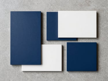 Minimalist industrial flat-lay of clean geometric material samples in shades of deep indigo and warm white, arranged on a neutral concrete surface, soft natural light.