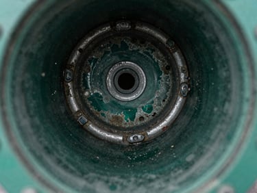 Close-up of a corroded pipe interior showing hard water scale buildup, crisp technical lighting, deep green and metallic tones, sharp focus, 35mm lens