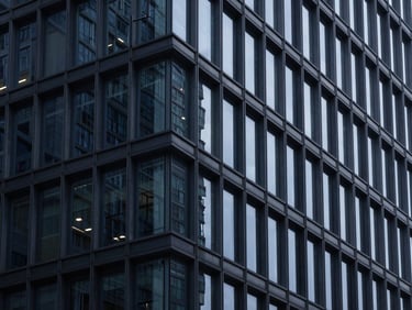 Abstract architectural details of a modern steel and glass building, cool clinical lighting, high contrast navy tones, 50mm.
