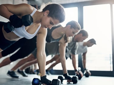 a group of people doing push ups on a gym floor