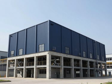 Modern industrial manufacturing facility with clean steel and concrete lines, wide-angle architectural shot, bright daylight
