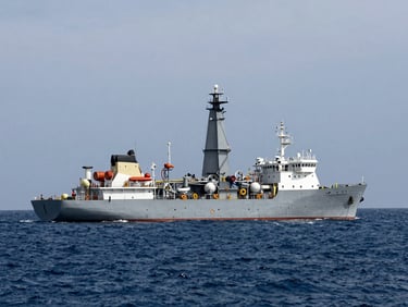 A large modern drillship positioned in the deep ocean, high-contrast Gulf of Mexico sun.