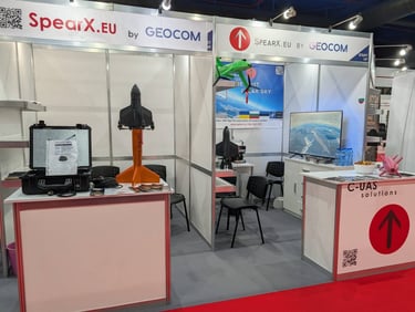 SpearX.eu by GEOCOM exhibition booth featuring a rocket booster model and C-UAS drone defense solutions.