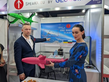 Representatives showcasing SpearX AI-guided interceptor UAV drone models at a technology exhibition booth.