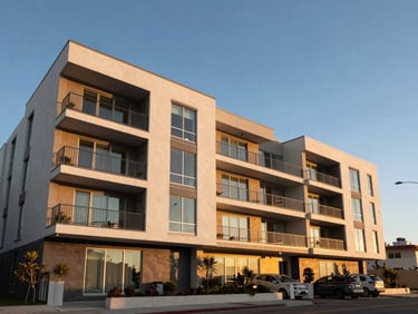Wide-angle architectural photography of a modern multi-family duplex in Manhattan Beach at golden hour, clean geometric lines, blue sky.