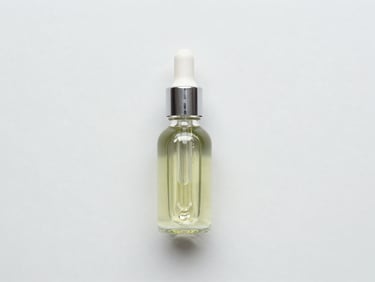 Overhead flat-lay of a glass dropper with clean herbal oil, minimalist light background
