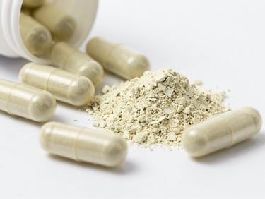 Close-up of pure botanical powder next to clean gelatin capsules, daylight, sage green accent
