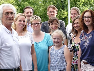 Foto von 9 Gründungsmitgliedern mit einem Kind