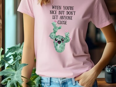 Woman wearing a pink graphic plant t-shirt with a cute smiling cactus design from Miss Chatty Plants.