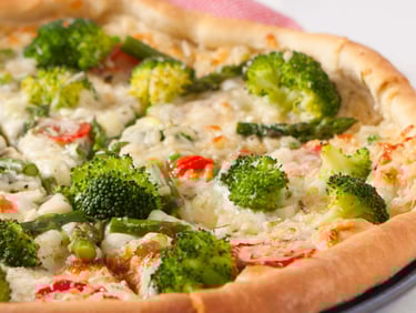 a pizza with broccoli and cheese on a plate