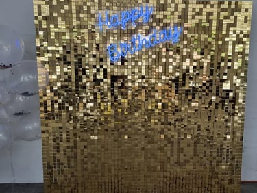 Blue happy birthday neon sign on a gold shimmer wall for Tipene's daughter in Logan.
