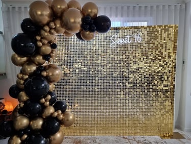 Gold shimmer wall with matching gold and black garland for sweet 16 in Brisbane.