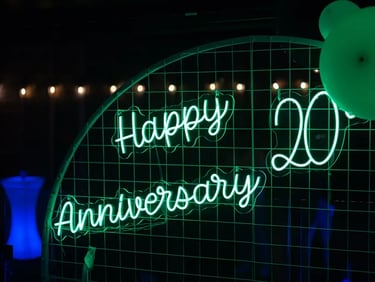 Green happy 20th anniversary neon sign on circle backdrop at vow renewal Redlands.