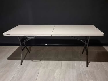Folding lifetime table with a white spandex cover available for hire in Redlands.