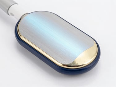 Detailed macro view of a cryolipolysis applicator head, cryogenic metallic plates with soft blue light reflections, clean medical suite environment.