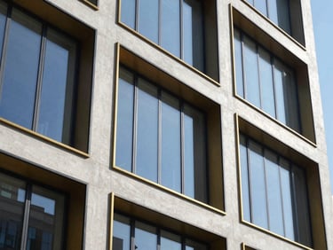 Sleek modern commercial building facade, concrete and glass, bright daylight, architectural photography