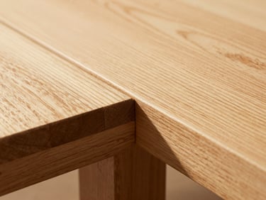 Tight macro shot of a flawless mortise and tenon joint on a white oak table, showing the precise alignment of the wood grains, 35mm