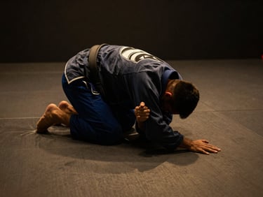 BJJ instructor demonstrating a precise armbar on a clean mat, close-up of technique, dramatic low-key side lighting, deep charcoal and warm amber tones, 35mm lens.