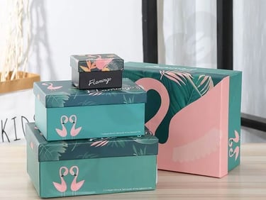 a stack of three boxes with a pink flamingo on top