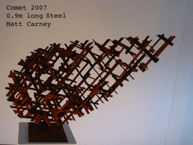 a rusted steel cross-hatched comet shaped sculpture