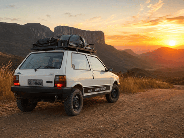 White Fiat Uno camper off-road vehicle parked on a mountain dirt road during a golden sunset.