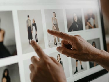 Close-up of a designer's hands reviewing creative mockups on a screen, subtle reflections, tactile feel, natural London daylight, shallow depth of field, off-center composition.