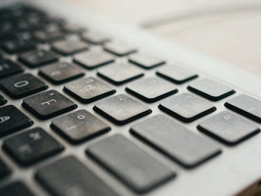 Macro detail of a keyboard or mouse on a desk, subtle light, focus on precision, editorial framing, natural London daylight.