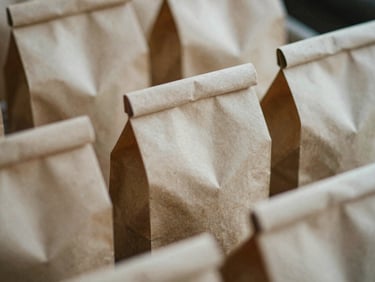 Tactile close-up of artisanal food packaging, soft shadows, off-center, 35mm film grain.