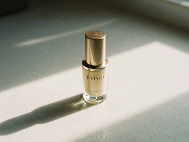 Editorial close-up of luxury skincare product on a textured surface, soft shadows, off-center, overcast London daylight, 35mm film grain.