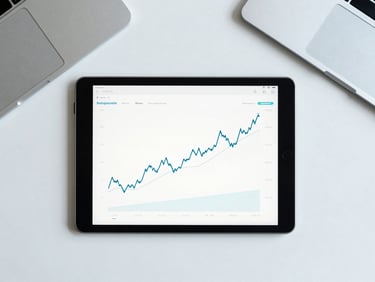 Overhead flat lay of a modern organized desk with a tablet displaying clean financial charts, bright natural daylight with subtle cool blue tones, sharp focus, 35mm