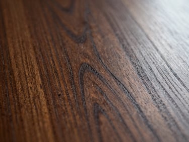 Macro close-up of restored mahogany wood grain, rich satin luster, soft overcast natural light.