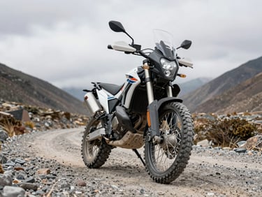 Low-angle front-quarter view of an adventure motorcycle on a gravel Andean mountain pass, rugged tires and long-travel suspension forks in sharp focus, overcast daylight, stone terrain visible