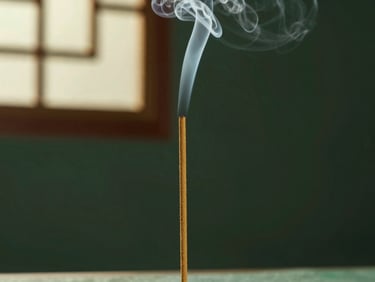 A single stick of natural herbal incense burning slowly, a thin wisp of smoke rising in a dark green room, soft golden light