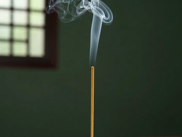 A single stick of natural herbal incense burning slowly, thin elegant smoke plume, serene dark green background