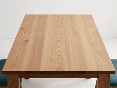 Studio shot of a minimalist solid petiribi wood dining table, clean white background, soft natural side light, showing rich grain, architectural interior style
