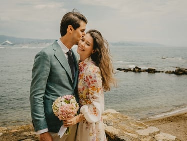 Groom kisses bride on the cheek by the sea — fine art wedding photography South of France