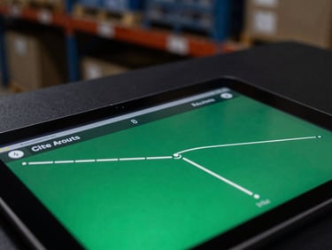 Macro shot of industrial tablet displaying real-time routing interface, dark warehouse background, sharp focus, emerald accents.