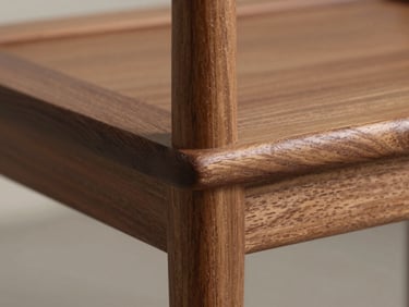 Close-up of a solid walnut chair joint, showing precise architectural craftsmanship and clean structural lines