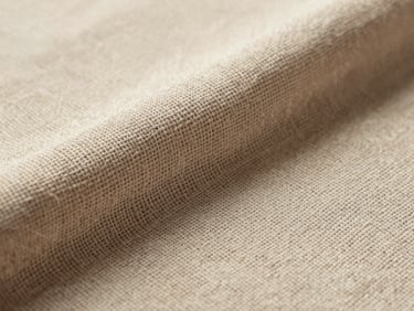 Macro texture shot of heavy-wear woven linen fabric, warm side-lighting highlighting the intricate thick yarn structure